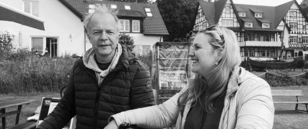 Bürgermeister Thomas Gens und Kulturdirektorin Vanessa Marx vor Gebäuden auf Hiddensee